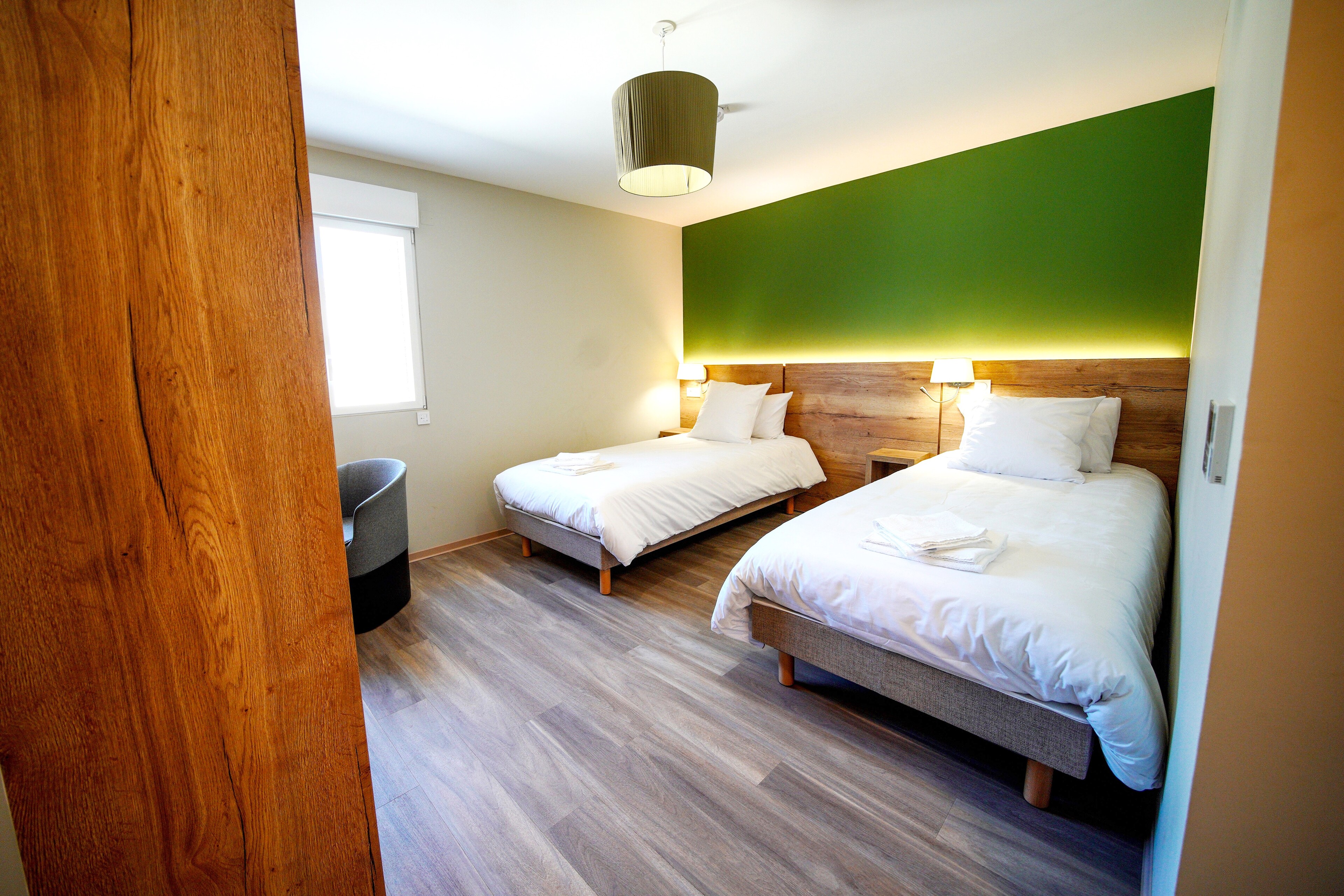 Limage représente une chambre avec 2 lits simples et accessible aux personnes à mobilité réduite. Elle permet daccéder à la catégorie hébergement