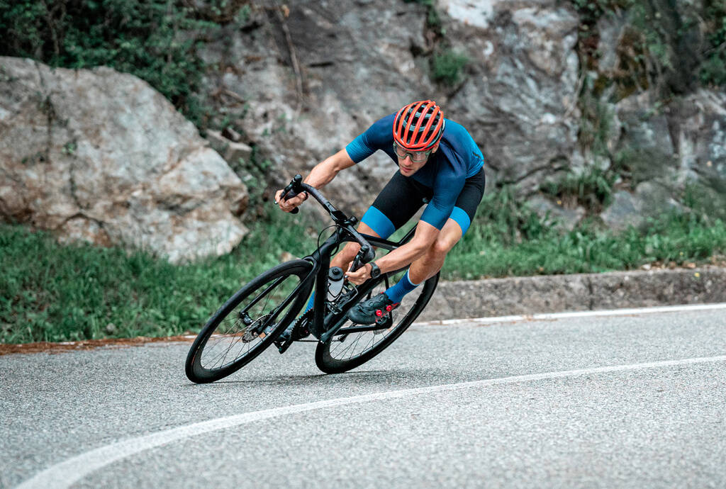 Cycliste sur une route de montagne en descente dans un virage